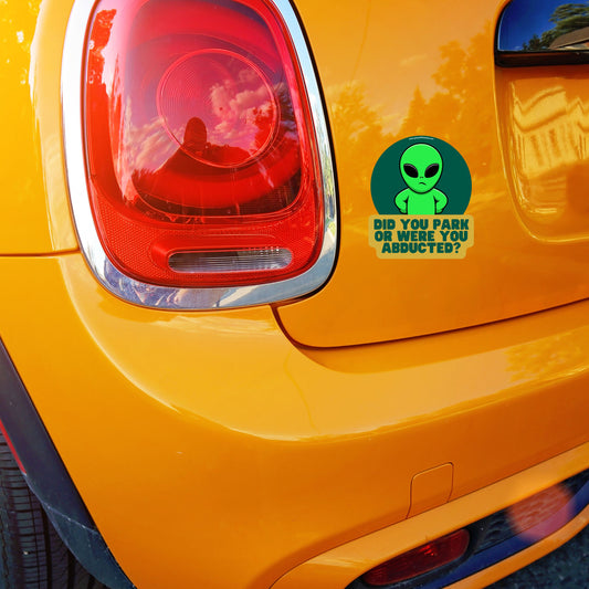 Funny car sticker with text 'Did You Park or Were You Abducted?' on orange Mini Cooper