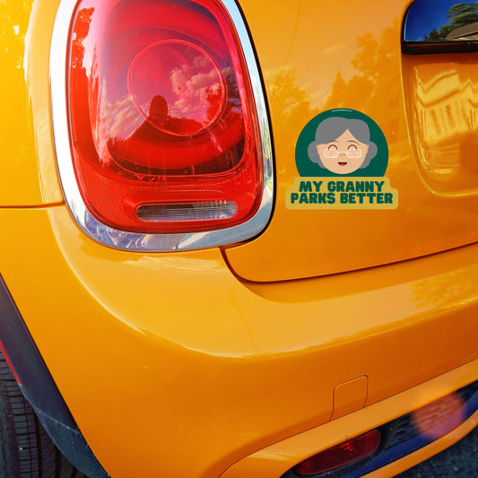 Humorous car sticker with text 'My Granny parks better' on orange Mini Cooper