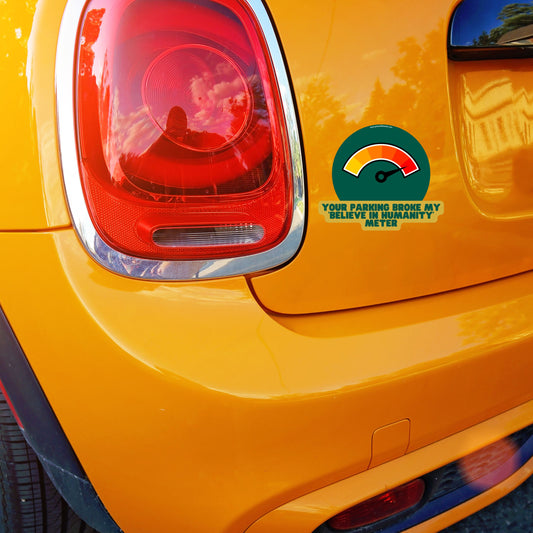 Humorous car sticker with text 'Your Parking Job Broke My 'Believe in Humanity' Meter' on orange Mini Cooper